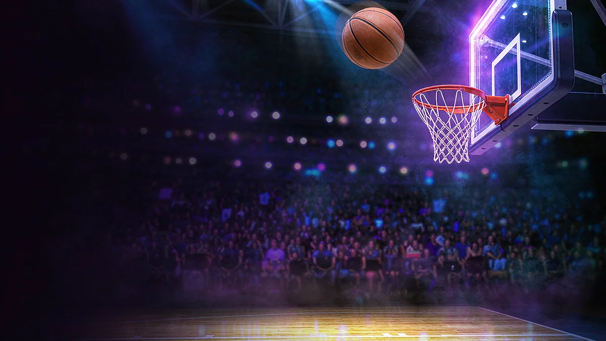Basketball approaching a hoop in a brightly lit arena